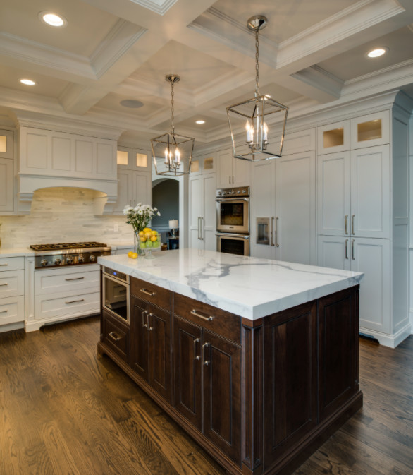 Large transitional u-shaped open plan kitchen in Detroit with an undermount sink, shaker cabinets, white cabinets, marble benchtops, white splashback, matchstick tile splashback, white appliances, dark hardwood floors and with island.