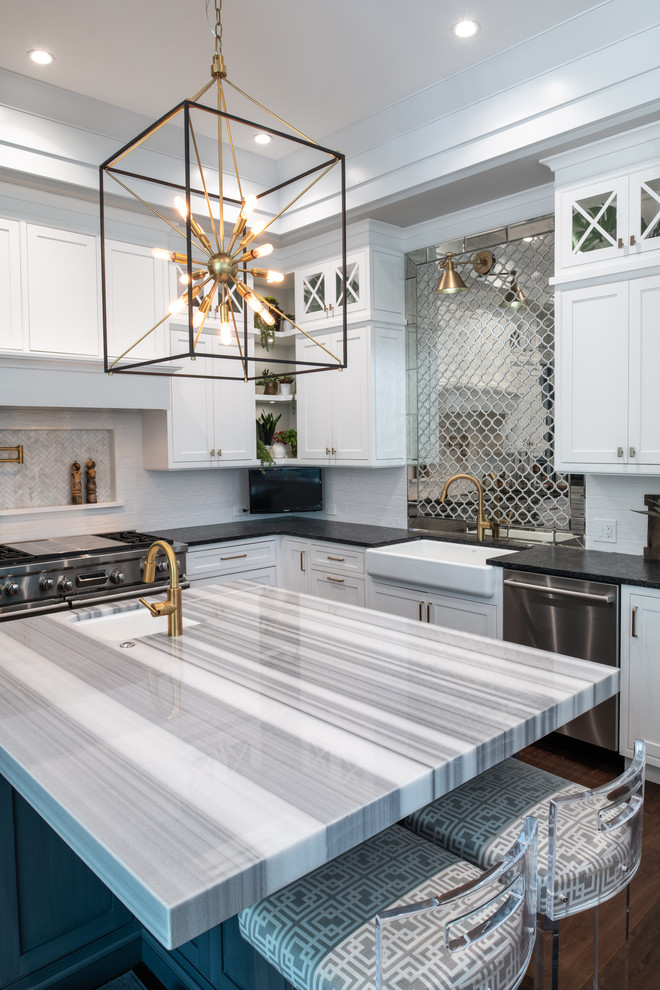Design ideas for a mid-sized transitional u-shaped kitchen in Tampa with a farmhouse sink, flat-panel cabinets, white cabinets, marble benchtops, mirror splashback, stainless steel appliances and with island.