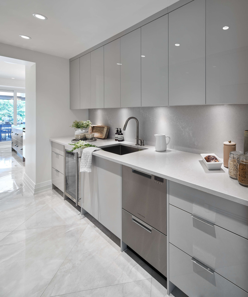 Example of a mid-sized trendy l-shaped gray floor eat-in kitchen design in Ottawa with an undermount sink, flat-panel cabinets, gray cabinets, gray backsplash, stainless steel appliances and gray countertops
