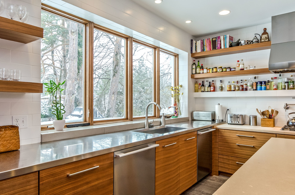 Design ideas for a mid-sized modern u-shaped separate kitchen in Grand Rapids with a drop-in sink, flat-panel cabinets, light wood cabinets, concrete benchtops, white splashback, stainless steel appliances, ceramic floors and with island.