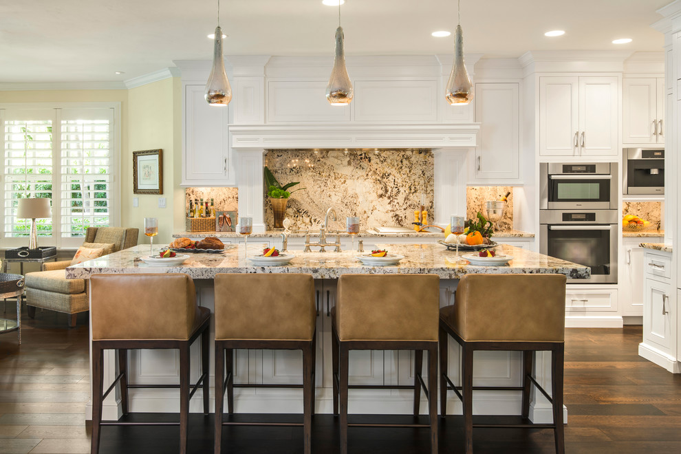 Mid-sized contemporary galley eat-in kitchen in Miami with recessed-panel cabinets, stainless steel appliances, white cabinets, stone slab splashback, a farmhouse sink, granite benchtops, multi-coloured splashback, medium hardwood floors, with island and brown floor.
