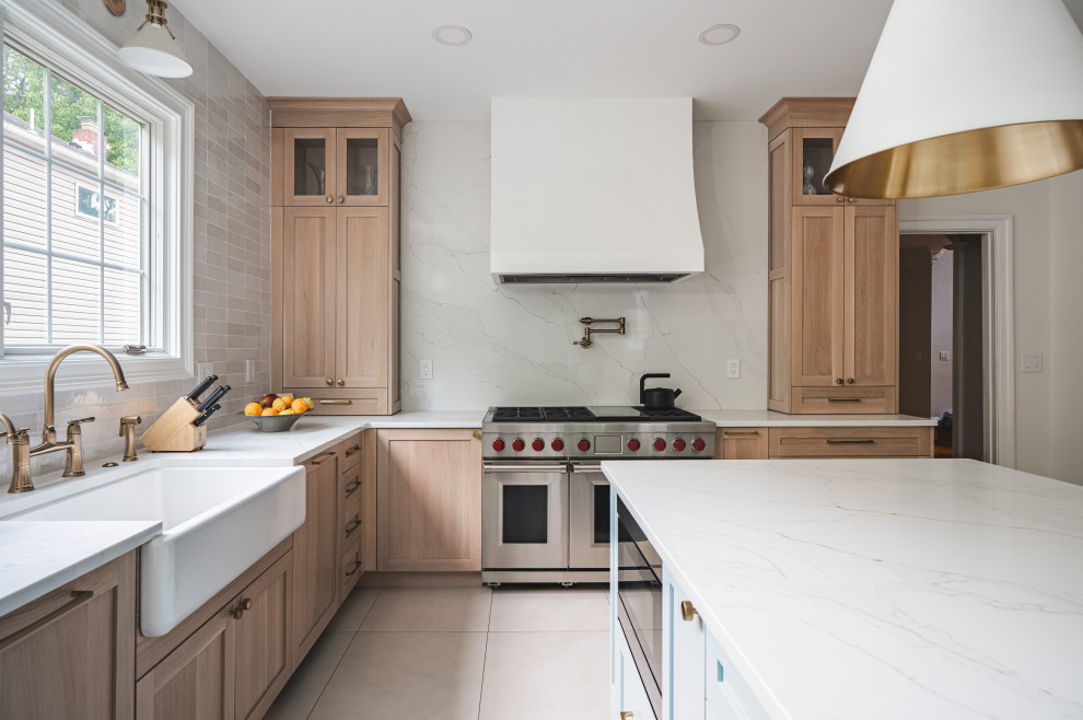 Large danish u-shaped porcelain tile and white floor eat-in kitchen photo in DC Metro with brown cabinets, quartzite countertops, beige backsplash, stainless steel appliances, an island, a farmhouse sink, shaker cabinets, ceramic backsplash and white countertops