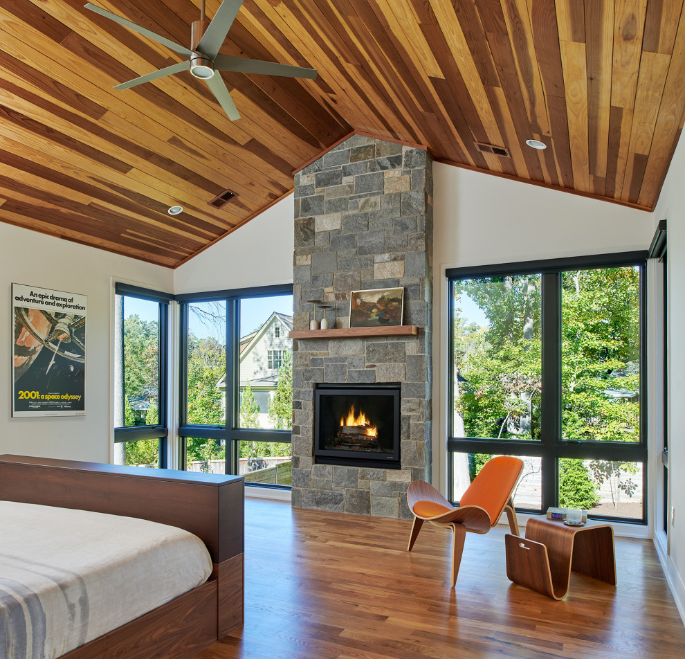 ワシントンD.C.にある中くらいなミッドセンチュリースタイルのおしゃれな主寝室 (白い壁、無垢フローリング、標準型暖炉、石材の暖炉まわり、オレンジの床、板張り天井)