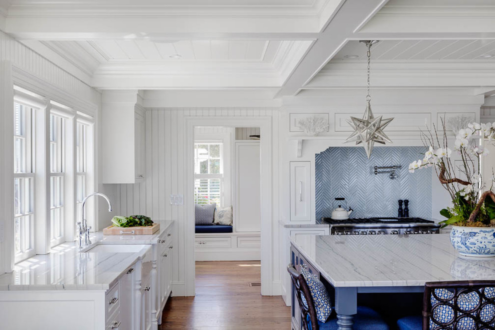 Design ideas for a large beach style single-wall eat-in kitchen in Boston with with island, shaker cabinets, marble benchtops, stainless steel appliances, medium hardwood floors, a farmhouse sink, white cabinets, blue splashback and metal splashback.