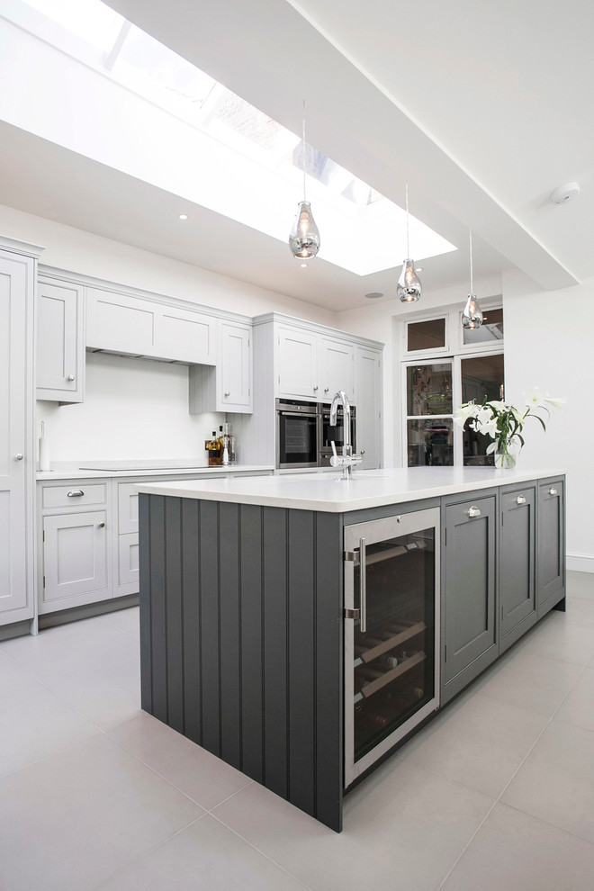 Inspiration for a large contemporary u-shaped eat-in kitchen in London with a single-bowl sink, shaker cabinets, grey cabinets, granite benchtops, white splashback, ceramic splashback, panelled appliances, ceramic floors, with island, white floor and white benchtop.