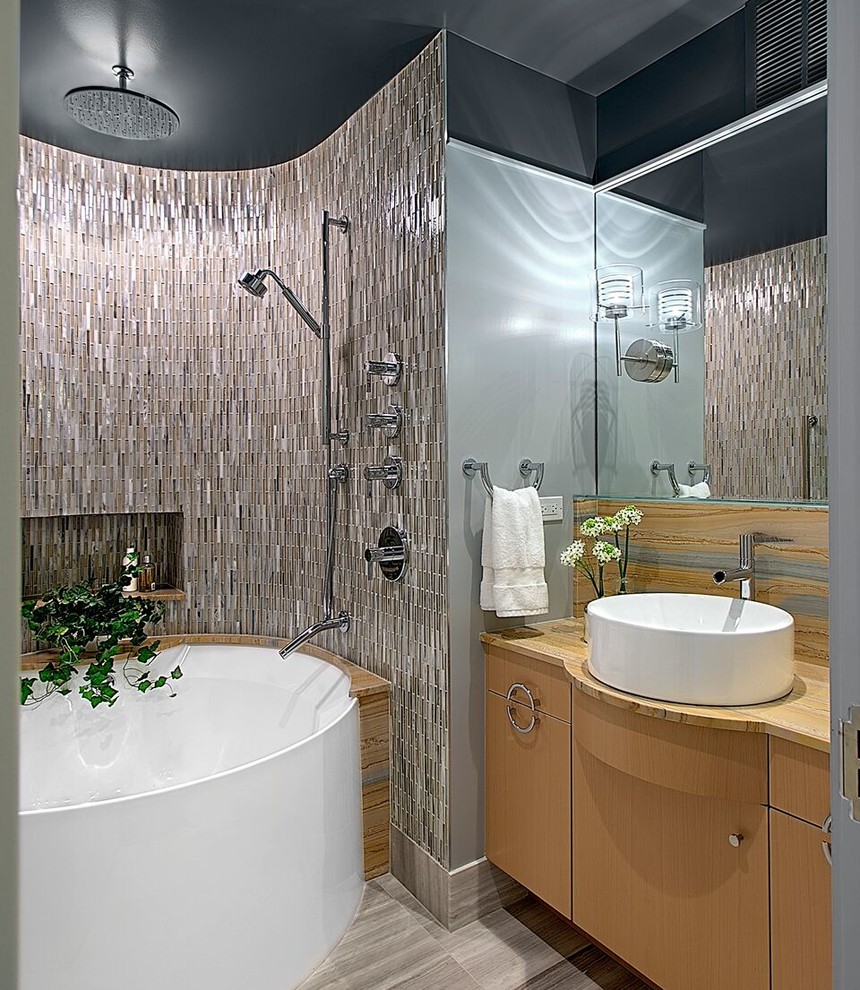 Mid-sized contemporary master bathroom in Chicago with flat-panel cabinets, light wood cabinets, an alcove tub, a shower/bathtub combo, beige tile, glass tile, grey walls, slate floors, a vessel sink and limestone benchtops.