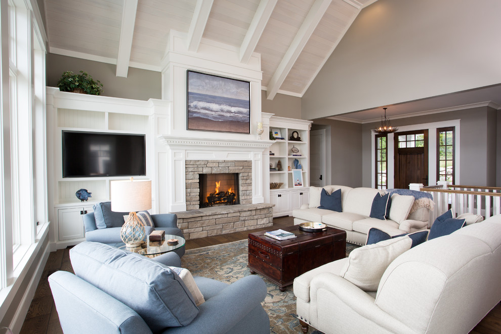 Mid-sized beach style open concept dark wood floor and brown floor family room photo in Other with beige walls, a standard fireplace, a stone fireplace and a wall-mounted tv