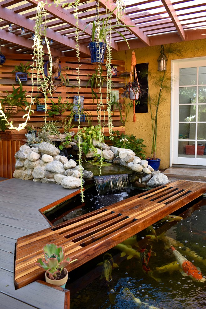 Mid-sized eclectic backyard deck in Los Angeles with a vertical garden and a pergola.