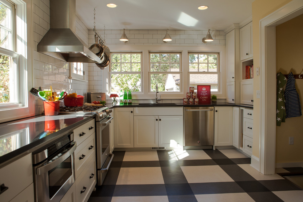 Design ideas for a traditional kitchen in Minneapolis with stainless steel appliances, white cabinets, quartz benchtops, white splashback, subway tile splashback and multi-coloured floor.