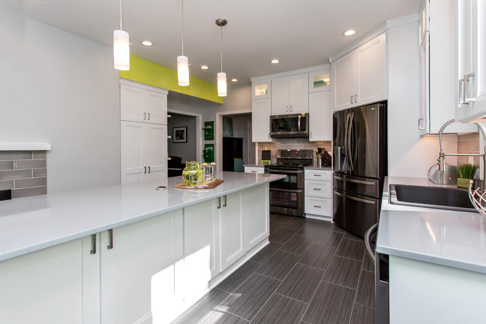 Enclosed kitchen - mid-sized transitional u-shaped porcelain tile enclosed kitchen idea with a drop-in sink, recessed-panel cabinets, white cabinets, quartz countertops, gray backsplash, ceramic backsplash, stainless steel appliances and an island