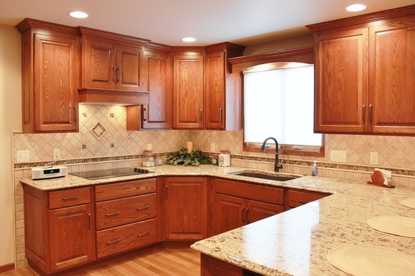 Inspiration for a mid-sized modern u-shaped light wood floor eat-in kitchen remodel with an undermount sink, raised-panel cabinets, medium tone wood cabinets, quartz countertops, multicolored backsplash, ceramic backsplash, stainless steel appliances and an island