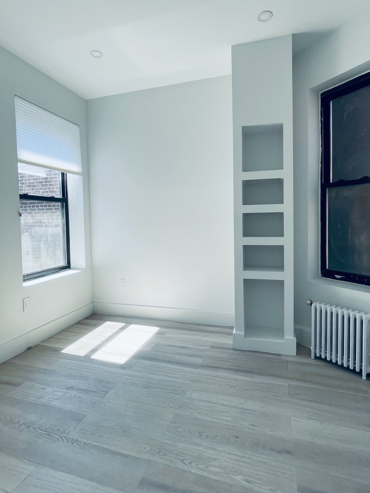 Aménagement d'une petite chambre classique avec un mur blanc, sol en stratifié et un sol gris.