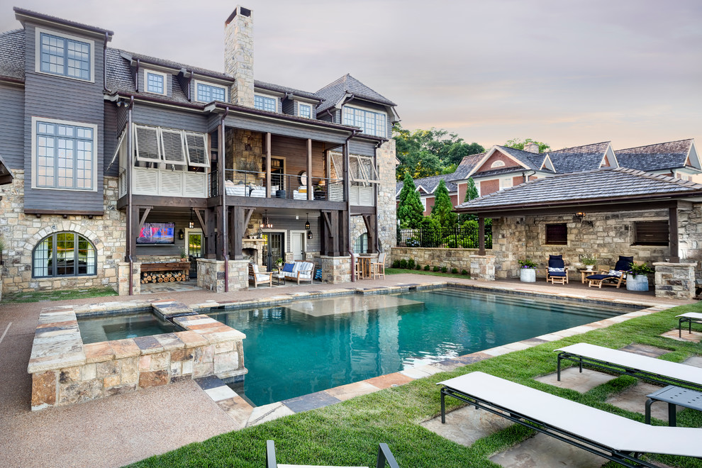 Example of a large mountain style backyard stone and rectangular hot tub design