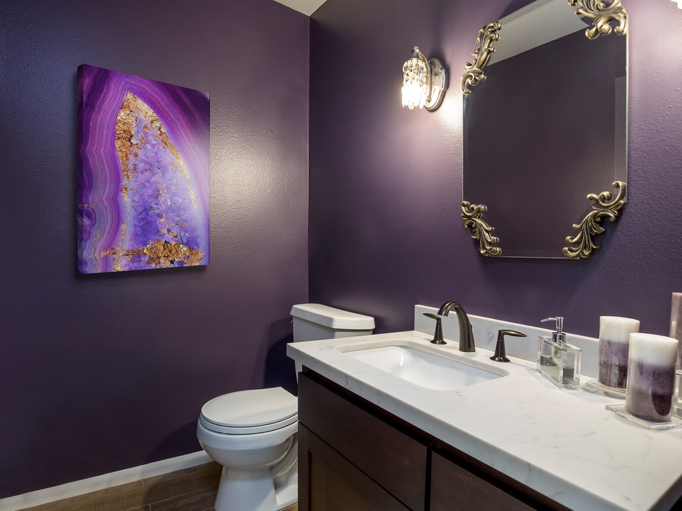 Inspiration for a mid-sized transitional powder room in Los Angeles with flat-panel cabinets, dark wood cabinets, a two-piece toilet, purple walls, porcelain floors, an undermount sink, engineered quartz benchtops and beige floor.
