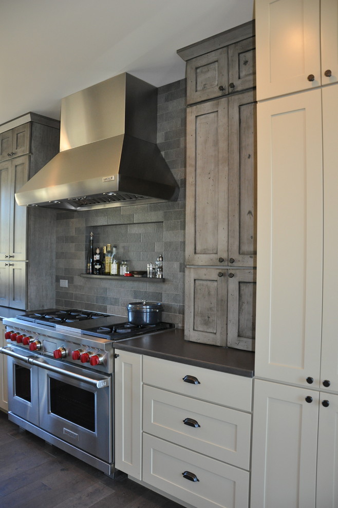 Large mountain style l-shaped medium tone wood floor eat-in kitchen photo in Seattle with an undermount sink, shaker cabinets, distressed cabinets, quartz countertops, gray backsplash, stone tile backsplash, stainless steel appliances and an island