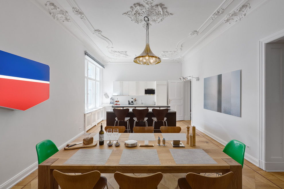 Mid-sized contemporary kitchen/dining combo in Berlin with white walls and medium hardwood floors.