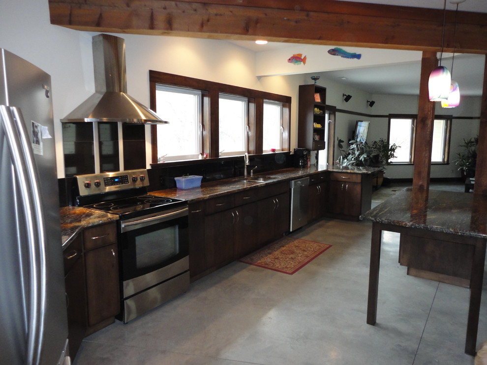 This is an example of a mid-sized transitional l-shaped kitchen in Kansas City with a drop-in sink, open cabinets, dark wood cabinets, granite benchtops, stainless steel appliances and concrete floors.