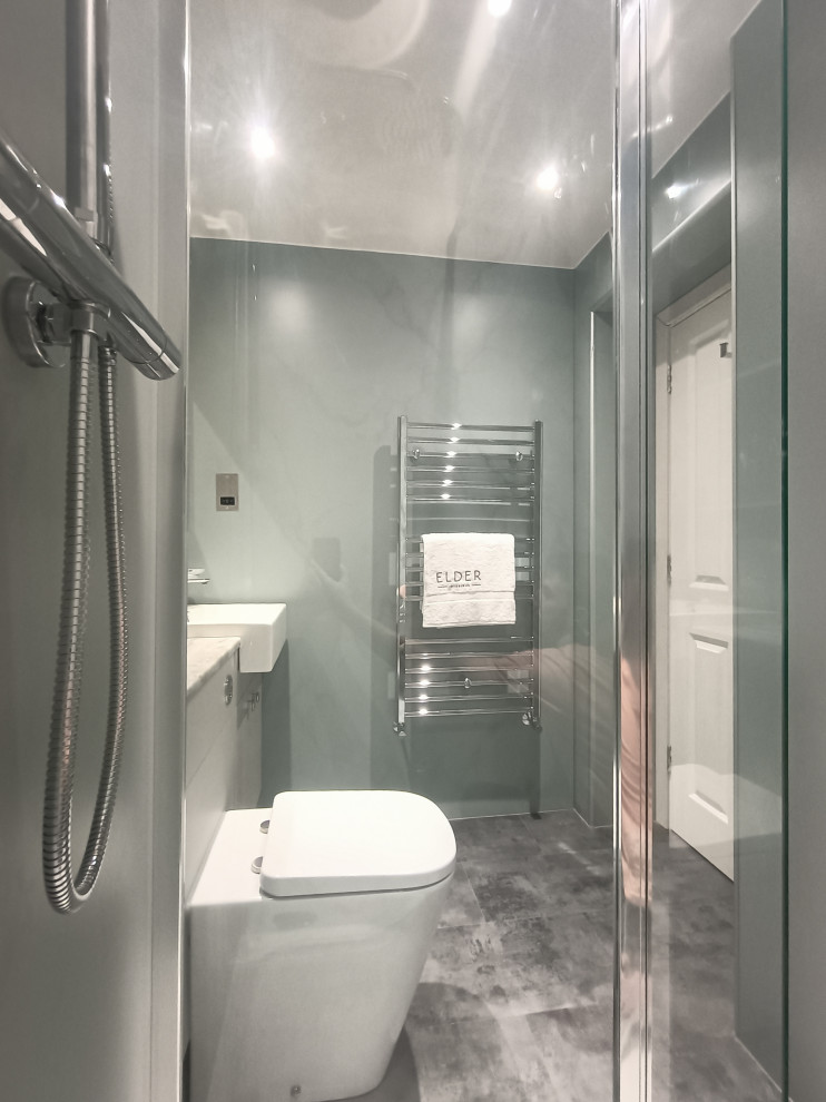 Inredning av ett modernt litet grå grått en-suite badrum, med släta luckor, grå skåp, en öppen dusch, en toalettstol med hel cisternkåpa, grön kakel, gröna väggar, vinylgolv, ett nedsänkt handfat, laminatbänkskiva, grått golv och med dusch som är öppen