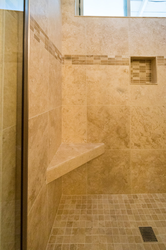 This is an example of a mid-sized traditional master bathroom in San Diego with recessed-panel cabinets, medium wood cabinets, an alcove shower, a two-piece toilet, beige tile, ceramic tile, beige walls, travertine floors, a drop-in sink, engineered quartz benchtops, a sliding shower screen, beige benchtops, a double vanity and a built-in vanity.