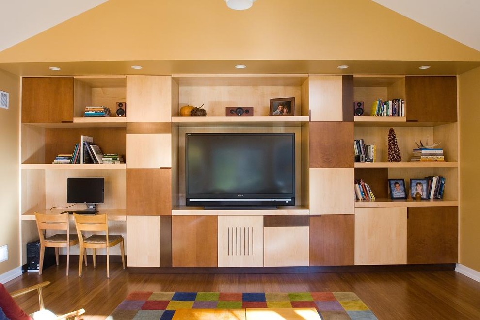 This is an example of an eclectic family room in Chicago with beige walls, medium hardwood floors and a built-in media wall.