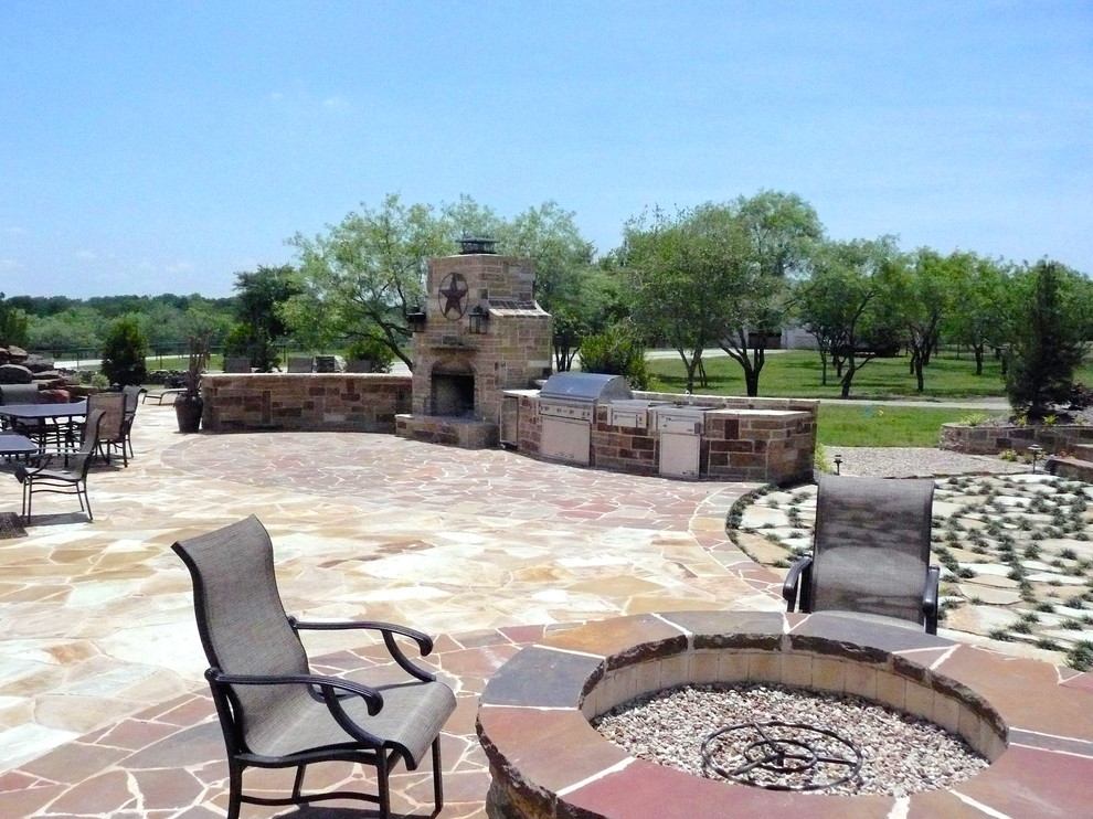 Foto di un grande patio o portico country dietro casa con pavimentazioni in pietra naturale