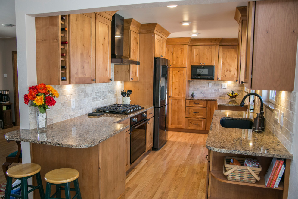 Inspiration for a mid-sized rustic galley medium tone wood floor and brown floor eat-in kitchen remodel in Denver with an undermount sink, shaker cabinets, medium tone wood cabinets, quartz countertops, gray backsplash, stone tile backsplash, black appliances, no island and brown countertops