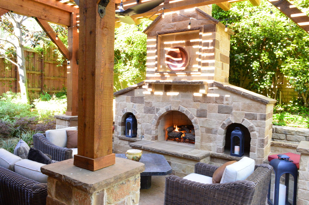 Inspiration for a mid-sized mediterranean backyard patio in Dallas with a fire feature, natural stone pavers and a pergola.