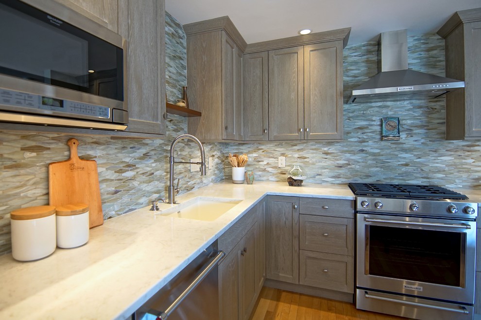 Inspiration for a mid-sized transitional l-shaped medium tone wood floor and beige floor eat-in kitchen remodel with an undermount sink, beaded inset cabinets, distressed cabinets, marble countertops, gray backsplash, ceramic backsplash, stainless steel appliances, an island and white countertops