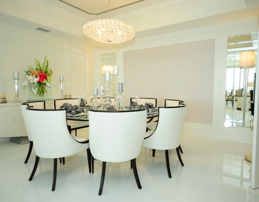 Modern kitchen/dining combo in Miami with white walls and marble floors.