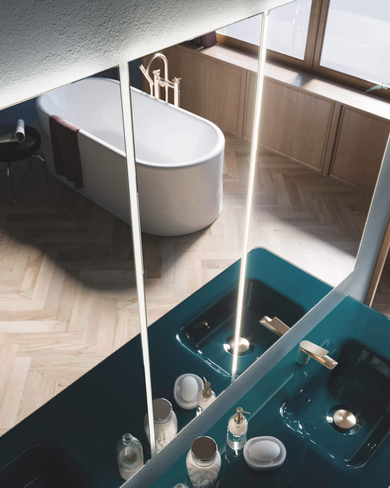 Cette image montre une grande salle de bain principale minimaliste avec des portes de placards vertess, une baignoire indépendante, parquet clair, un lavabo intégré, un plan de toilette vert et meuble double vasque.