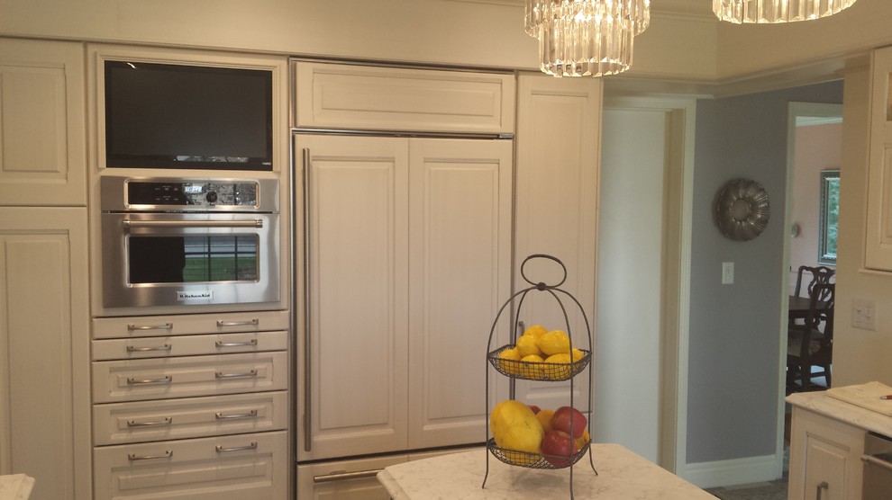 Inspiration for a small transitional u-shaped ceramic tile eat-in kitchen remodel with an undermount sink, raised-panel cabinets, white cabinets, marble countertops, white backsplash, subway tile backsplash, stainless steel appliances and an island