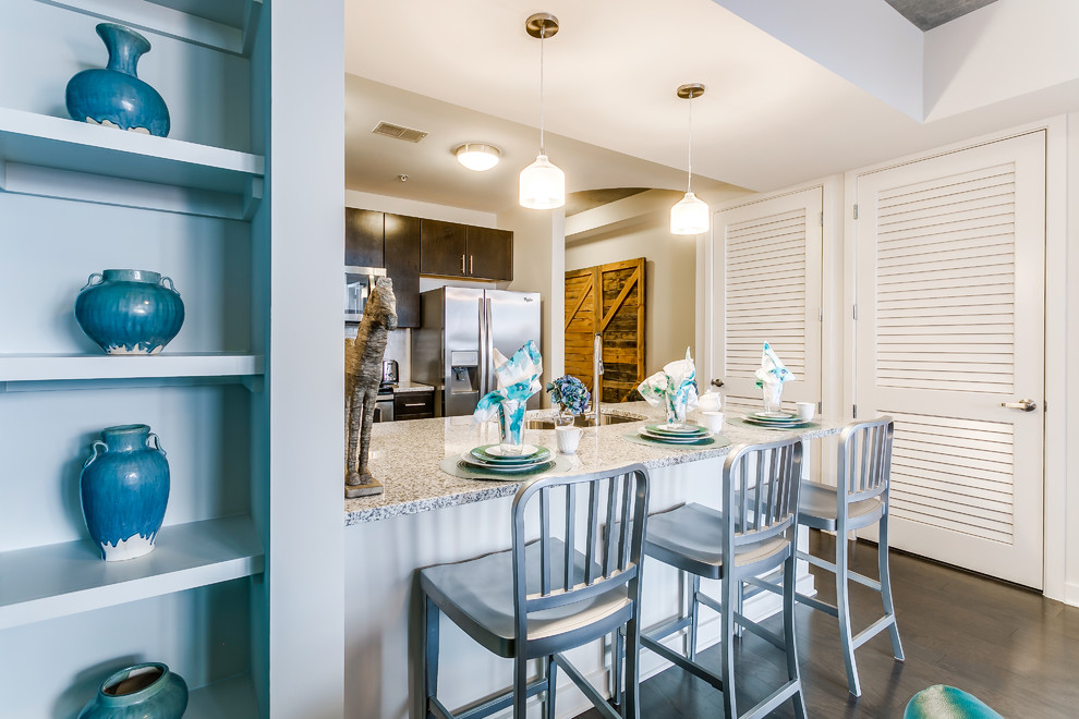 Small transitional medium tone wood floor and brown floor kitchen photo in Dallas with a double-bowl sink, glass-front cabinets, dark wood cabinets, granite countertops, white backsplash, marble backsplash, stainless steel appliances and an island