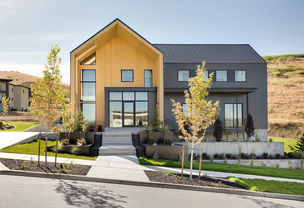Inspiration for a large contemporary two-storey black house exterior in Salt Lake City with a gable roof, a metal roof and mixed siding.