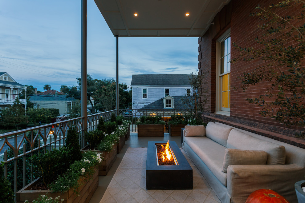 Design ideas for a mid-sized contemporary balcony in New Orleans with a fire feature, a roof extension and metal railing.