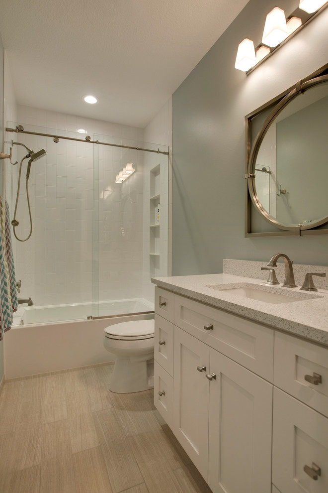 This is an example of a small arts and crafts kids bathroom in Minneapolis with shaker cabinets, white cabinets, an alcove tub, an alcove shower, a two-piece toilet, beige tile, porcelain tile, green walls, porcelain floors, an undermount sink and engineered quartz benchtops.