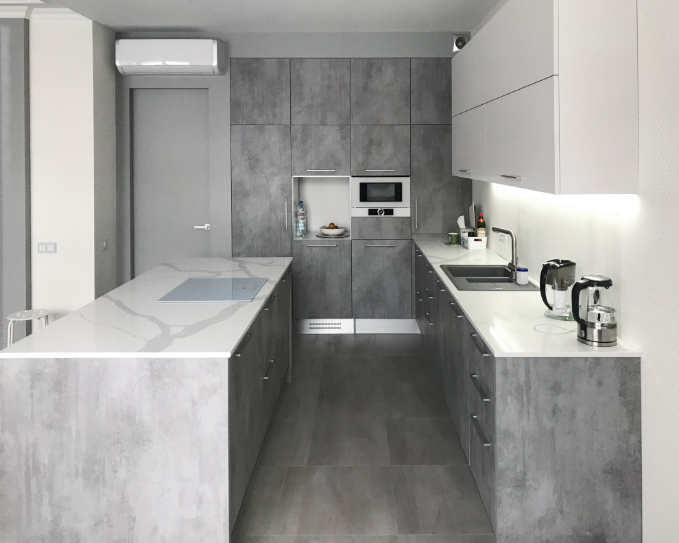 Design ideas for a contemporary l-shaped kitchen in Other with flat-panel cabinets, grey cabinets, white splashback, stainless steel appliances, with island, grey floor, white benchtop and coffered.