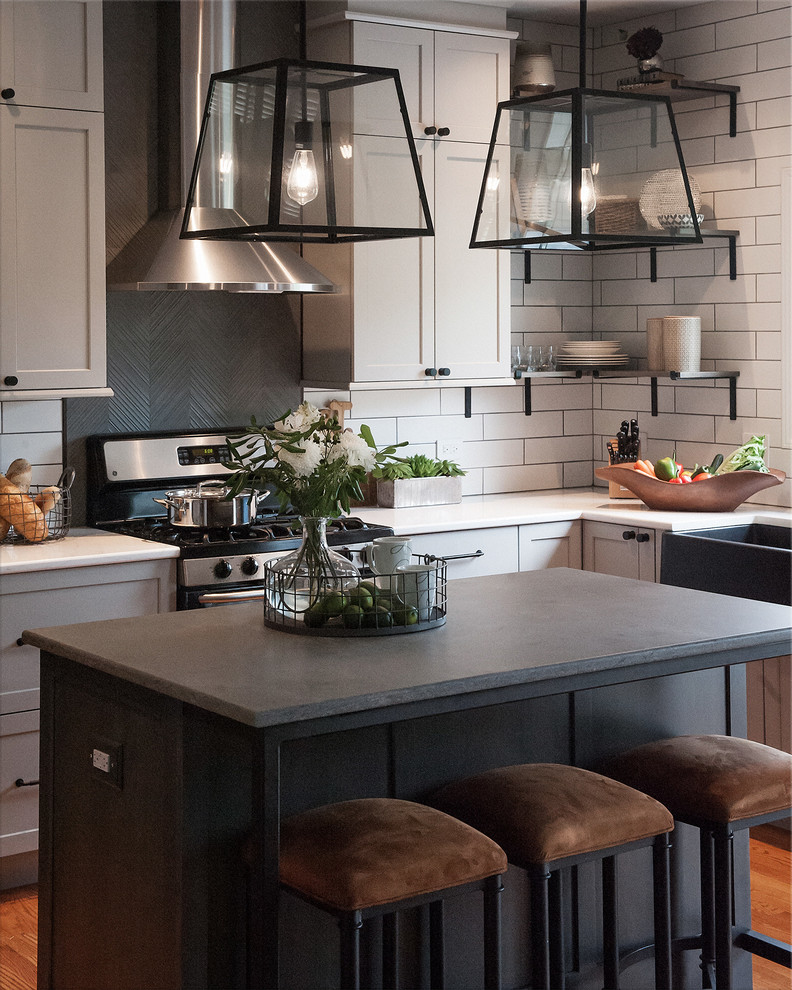 Photo of a mid-sized industrial u-shaped eat-in kitchen in Chicago with a farmhouse sink, shaker cabinets, grey cabinets, quartz benchtops, white splashback, ceramic splashback, stainless steel appliances, light hardwood floors, with island, beige floor and grey benchtop.