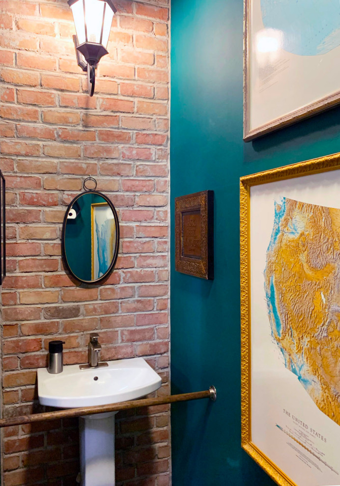 Small industrial 3/4 bathroom in Salt Lake City with white cabinets, a wall-mount toilet, green tile, green walls, concrete floors, a pedestal sink, grey floor, an enclosed toilet, a single vanity, a freestanding vanity and brick walls.