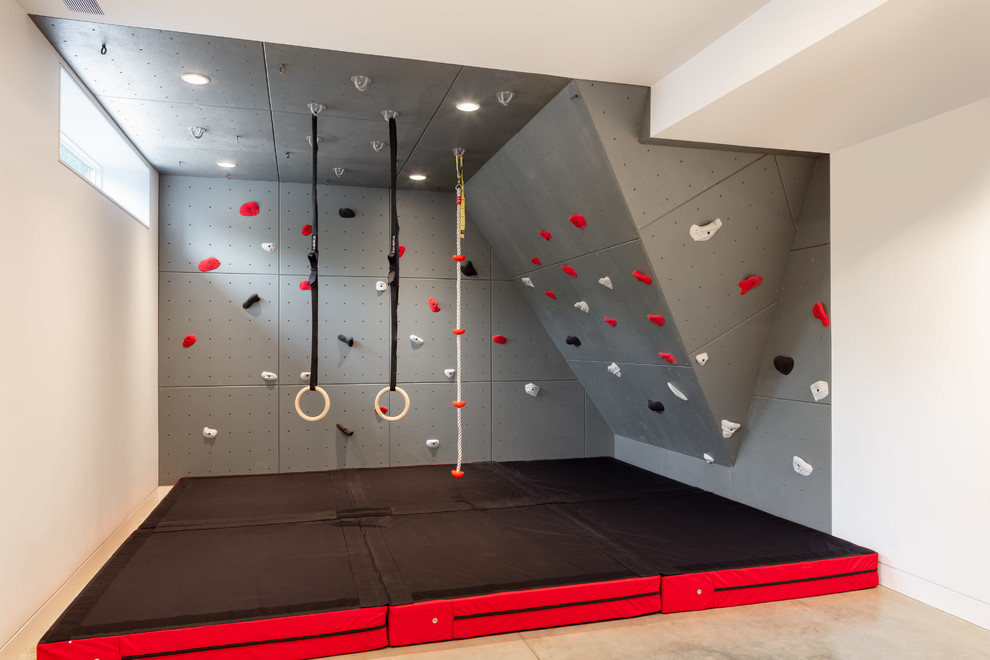 Photo of a large contemporary home climbing wall in Providence with white walls, concrete floors and beige floor.