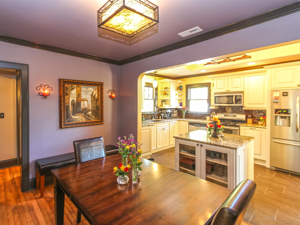 Small arts and crafts separate dining room in Charlotte with purple walls, light hardwood floors and no fireplace.