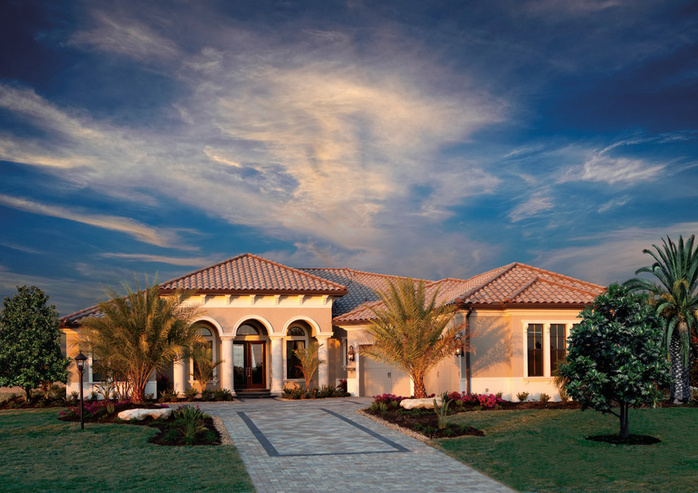 Large mediterranean one-story stucco exterior home idea in Tampa with a hip roof