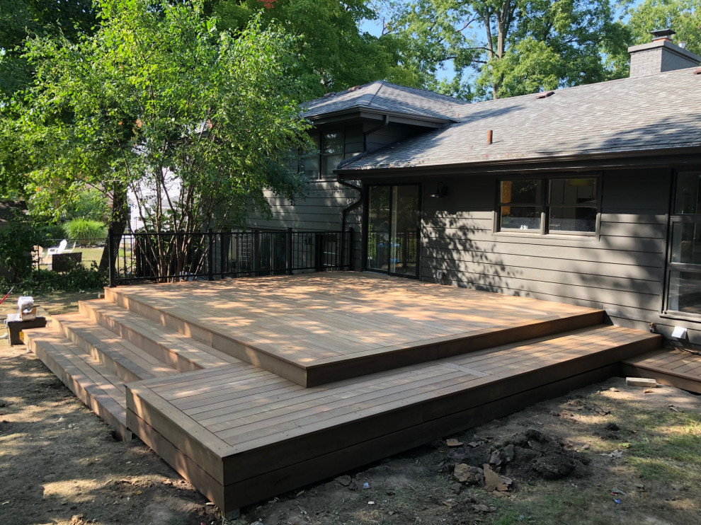 Example of a large trendy backyard ground level metal railing deck design in Grand Rapids with no cover