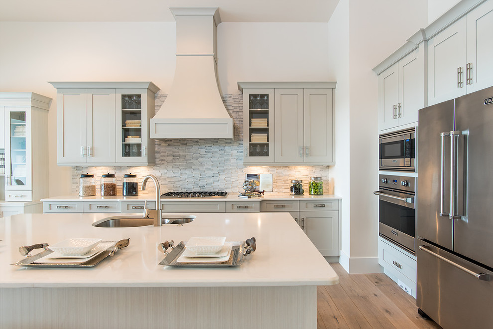 Inspiration for a large transitional u-shaped light wood floor eat-in kitchen remodel in Miami with a drop-in sink, flat-panel cabinets, gray cabinets, quartzite countertops, multicolored backsplash, stone tile backsplash, stainless steel appliances and an island