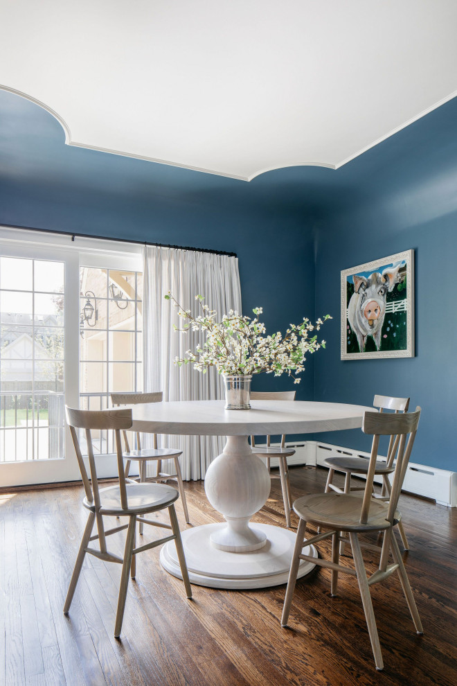 Réalisation d'une salle à manger tradition avec un mur bleu.