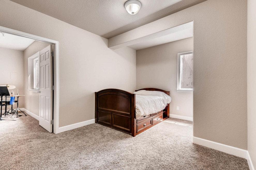 Mid-sized transitional look-out laminate floor basement photo in Denver with beige walls