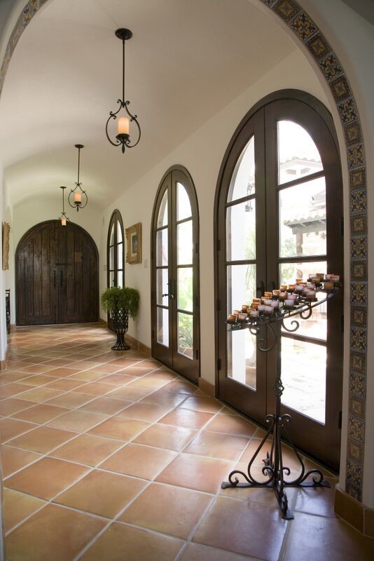 Design ideas for a mid-sized mediterranean hallway in Houston with beige walls, terra-cotta floors and brown floor.