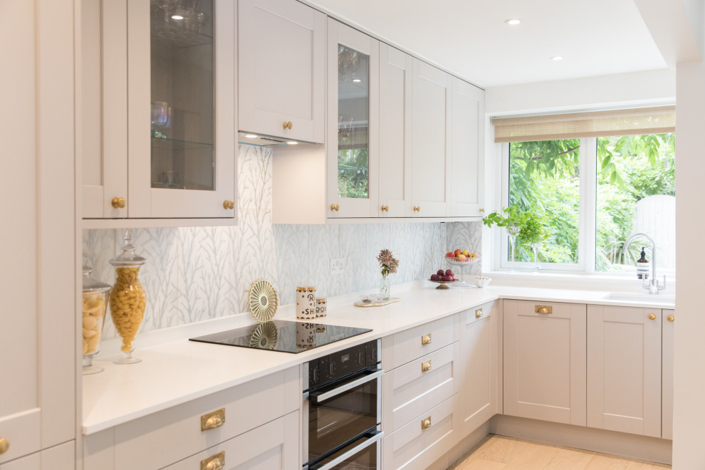 Inspiration for a small transitional l-shaped kitchen in London with an undermount sink, shaker cabinets, multi-coloured splashback, light hardwood floors, no island, beige floor and white benchtop.