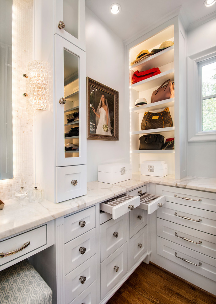 This is an example of a traditional women's dressing room in Dallas with white cabinets, shaker cabinets, dark hardwood floors and brown floor.