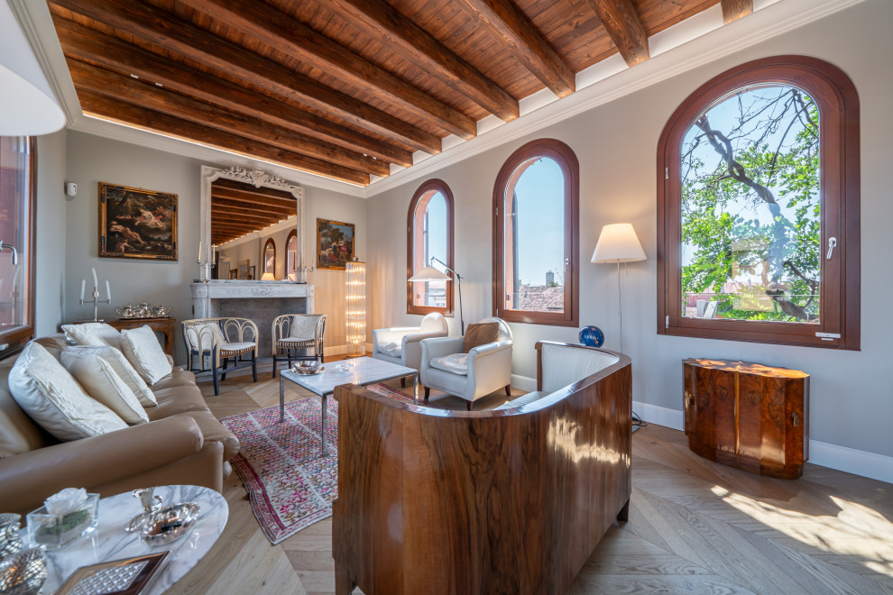 Esempio di un soggiorno mediterraneo con pareti grigie, parquet chiaro, pavimento beige, travi a vista e soffitto in legno