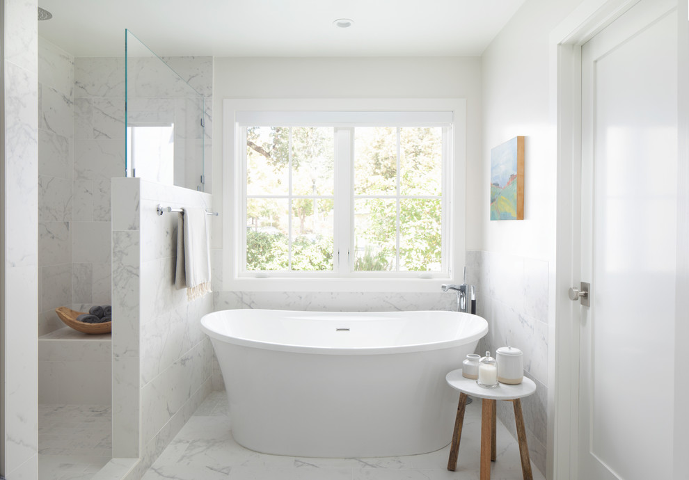 This is an example of a mid-sized country master bathroom in San Francisco with a freestanding tub, an alcove shower, white tile, porcelain tile, white walls, porcelain floors, white floor and a hinged shower door.